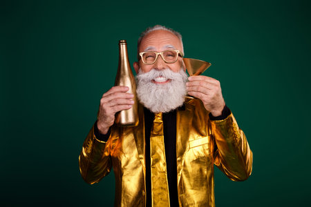 Elegant senior gentleman in golden suit celebrating holiday with charm and charismaの写真素材