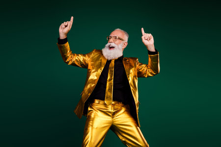 Elegant gentleman in a glowing golden suit dances joyfully, celebrating a festive holiday with charisma and styleの写真素材