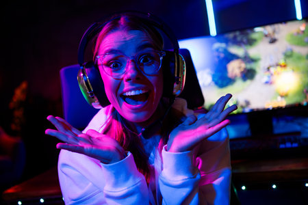 Photo of gamer lovely blonde young lady excited reaction play strategy game late night room indoors purple blue neon lightの写真素材