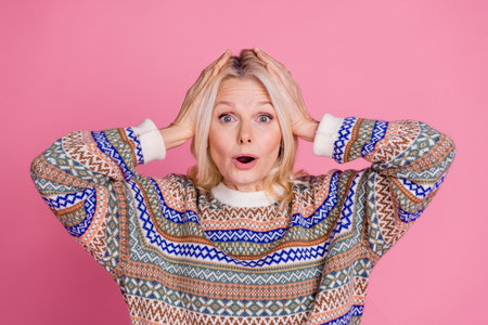 Photo of nice aged lady arms touch head open mouth wear pullover isolated on pink color background
