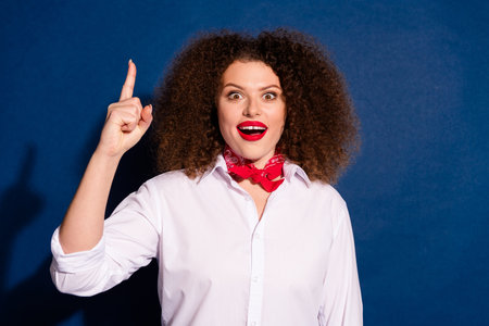 Photo of impressed positive woman wear white shirt pointing up empty space isolated blue color backgroundの写真素材
