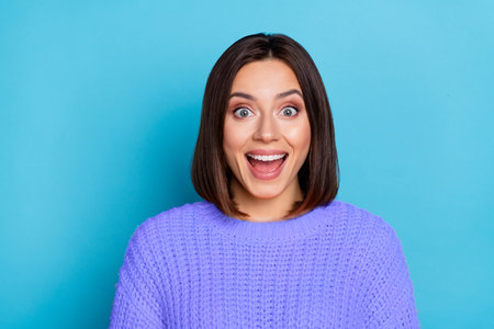 Portrait of attractive cheerful lucky amazed girl good incredible news reaction isolated over bright blue color backgroundの写真素材
