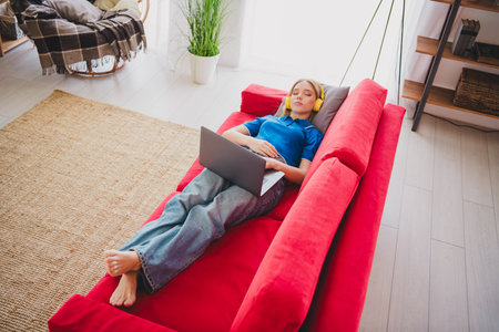 Photo of charming cute pretty girl wear stylish blue clothes on divan weekend indoors flat apartmentの写真素材