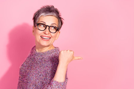 Photo of lovely woman wear jumper smiling showing thumb back empty space isolated pink color...