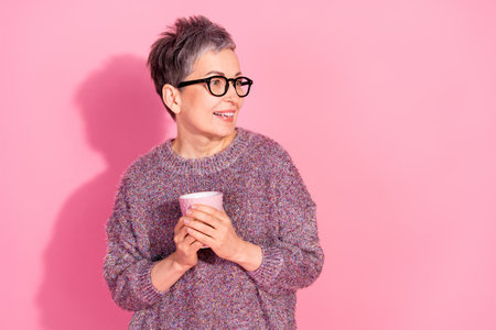 Photo of charming positive woman wear sweater enjoying coffee looking empty space isolated pink color backgroundの写真素材
