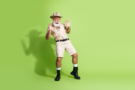 Photo of senior traveler looking down empty space wild danger isolated green color backgroundの写真素材