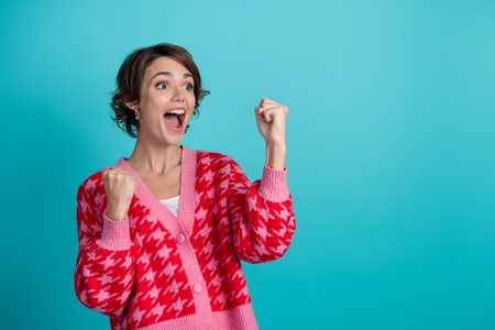 Photo portrait of lovely young lady look empty space winning dressed stylish red garment isolated on aquamarine color backgroundの写真素材