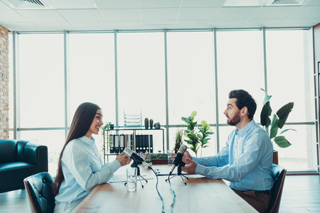 Two professionals recording a podcast in a modern workspace, symbolizing collaboration, creativity, and teamworkの写真素材