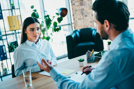 Professional workplace meeting between colleagues discussing project goals and strategies in a modern office environmentの写真素材