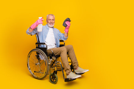 Funny cleanup moment grandpa in wheelchair sprays cleaner smiles during rehabの写真素材