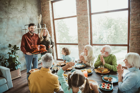 Funny cozy family feast at home as relatives gather around a golden turkey sharing laughter love and...