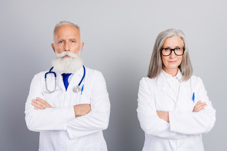 A cheerful woman in a red sweater lying among christmas gifts and a glowing tree smiling at the camera surrounded by festive lights and decorated gifts at homeの写真素材