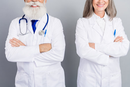 Two experienced doctors smiling for professional health care medical consultation themed image for clinics hospitals and patient careの写真素材