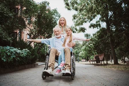 Family joy in the park a multi generation moment with grandpa in a wheelchair and kids smiling togetherの写真素材
