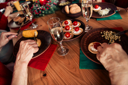 Family Christmas dinner setting with festive tableware cookies corn and drinks as relatives gather around a cozy home during winter eveの写真素材