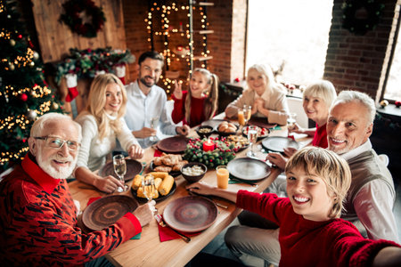 Family celebration at Christmas dinner around the table with a tree and festive decor in a cozy home...