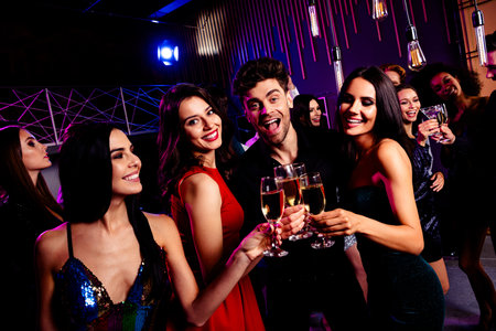 Fun filled night as friends toast at a glowing nightclub party under neon lights sharing laughter...