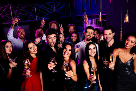 Nightlife party crowd cheers as friends toast at a stylish nightclub celebration with colorful...