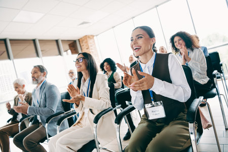 Diverse group of professionals applauding during a motivational presentation in a modern office environmentの写真素材