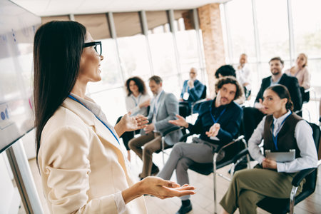 Professional woman giving a business presentation to an engaged diverse team during an office meeting focused on team collaborationの写真素材