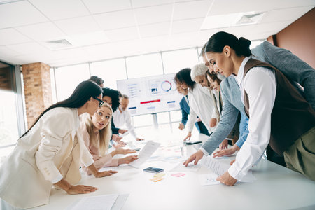 Diverse professionals engaged in teamwork during an office strategy sessionの写真素材