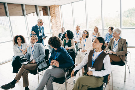 Diverse group of professionals participating in an engaging business workshop in a modern office environmentの写真素材