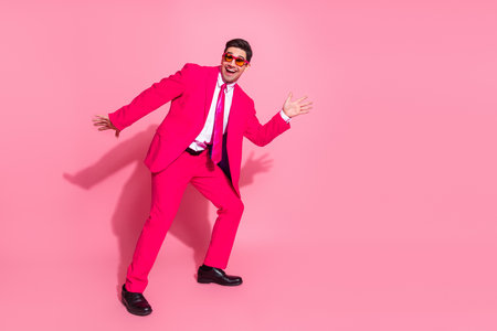 Energetic young man in pink suit showcasing vibrant charisma sparking bright fashionable inspirationの写真素材