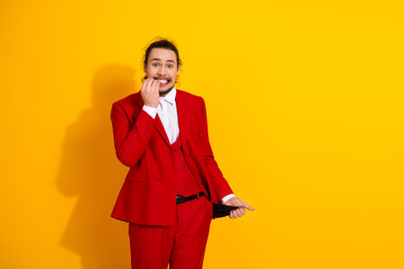Funny man in red suit poses against a bright yellow background showcasing a stylish corporate look for a playful promotional imageの写真素材