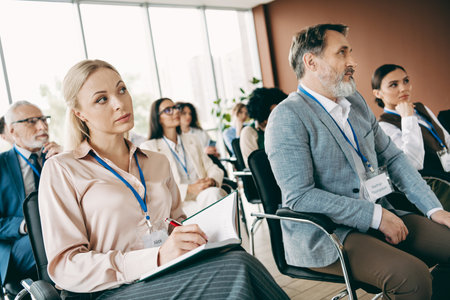 Group of professionals attentively participating in a corporate training session in a modern office setting for learningの写真素材