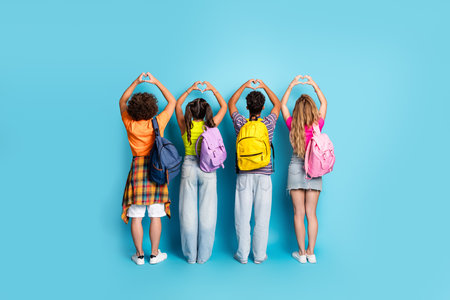 Four friends form heart shapes with colorful backpacks against a bright blue backdrop showing...