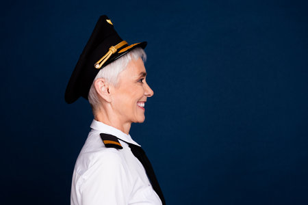 Photo portrait of attractive senior woman passenger plane captain profile dressed aviator uniform isolated on dark blue color backgroundの写真素材