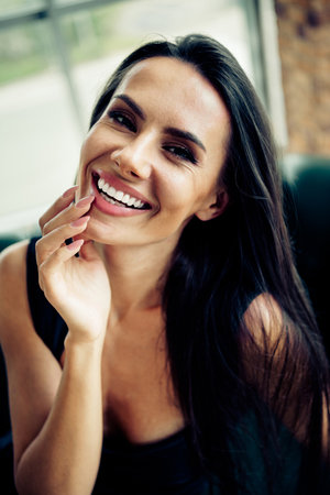 Portrait of a confident businesswoman with vibrant charm in an elegant attire posing indoors with a compelling smileの写真素材