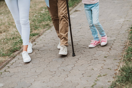 Playful walk trio on a sunlit path showing family bond and care as kids and adults enjoy togetherの写真素材