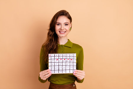 Young brunette woman smiling while holding calendar for shopping promotion imageの写真素材
