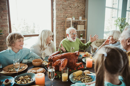 A warm family Thanksgiving feast as generations share joy around a big roasted turkey during a holiday dinner at homeの写真素材