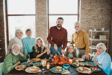A joyful family feast around a big turkey as generations gather for thanksgiving and a warm holiday dinnerの写真素材