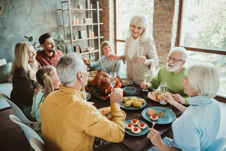 Funny warm family feast for thanksgiving a lively table full of laughter love and shared memories with extended family friendsの写真素材
