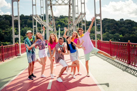 Group of young friends enjoying a cheerful afternoon outing on an urban bridgeの写真素材