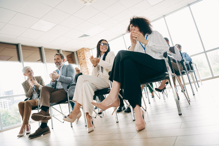 Professional team engaged in an interactive business meeting in a modern coworking space with a focus on collaboration and networkingの写真素材