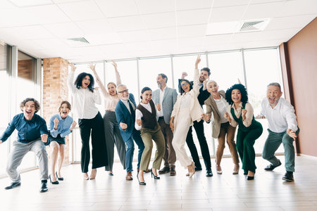 Cheerful office team celebrating success with positive energy and enthusiasm in a modern workplace setting with bright decorの写真素材