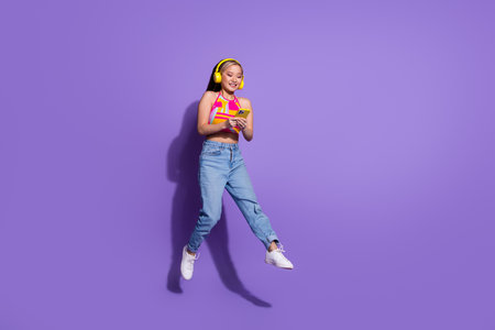 Photo of glad lovely cute girl wear trendy clothes listen audio stereo music playlist isolated on purple color backgroundの写真素材