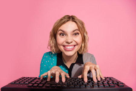 Photo portrait of pretty young girl look web camera typing keyboard wear trendy striped cyan outfit isolated on pink color backgroundの写真素材