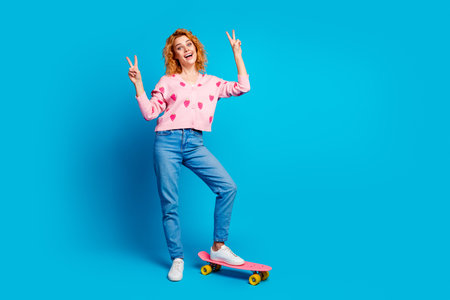Full length photo of attractive young woman ride skateboard v-sign dressed stylish pink clothes...