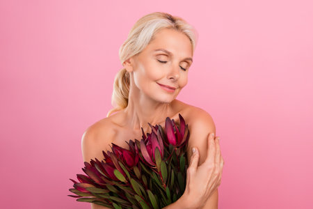 Photo of lovely lady hold hug fresh flower exotic wildflower floral product isolated on pink color backgroundの写真素材