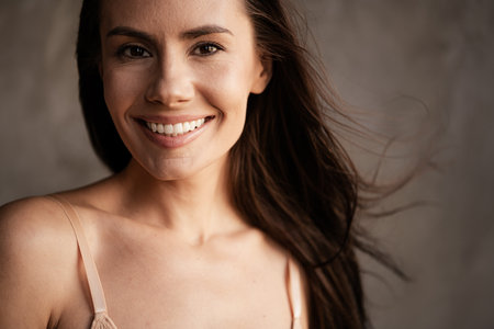 Photo of adorable cute lady toothy smile accepting herself natural face without makeup filters isolated on grey concrete wall backgroundの写真素材