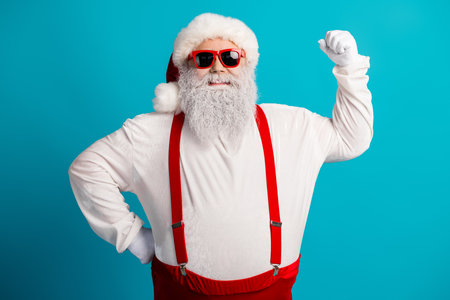 Santa with red suspenders on a bright blue backdrop radiates festive cheer and modern holiday styleの写真素材