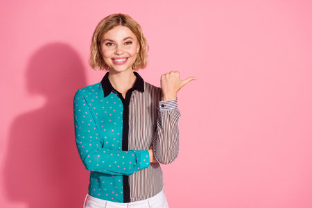 Photo of pretty young girl crossed hands confident pose point empty space wear trendy striped cyan...