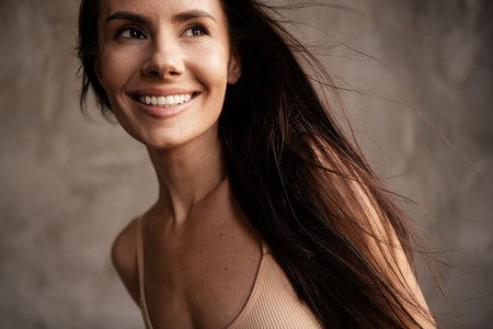 Portrait of lovely cheerful lady healthy perfect skin natural day light no filters isolated on grey concrete wall backgroundの写真素材