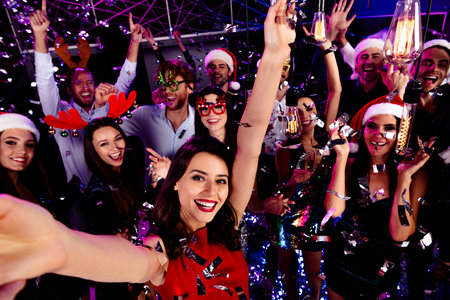 Epic office party night crowd dancing celebration with festive outfits and neon lights at a lively...
