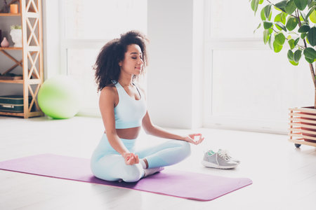 Full length photo of positive charming woman sportswear enjoying yoga indoors house apartment roomの写真素材